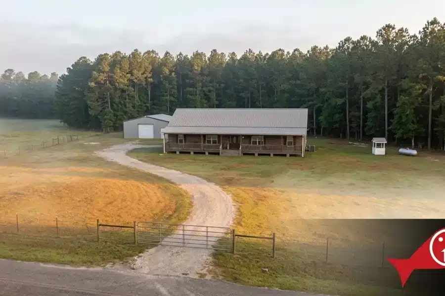Rural home on acreage near New Waverly, Texas with gravel drive, barn, and pine treeline